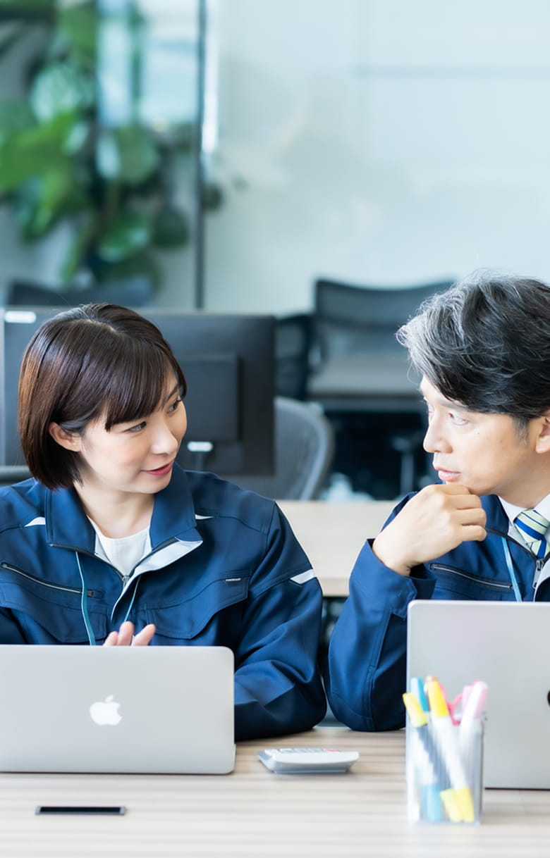 オフィスでパソコンを開きながらミーティングしている社員